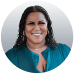 Brittney has long black curly hair, dark skin, and is wearing a teal blouse.