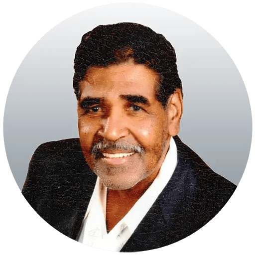Headshot of Jerry smiling wearing a blazer and collard shirt.