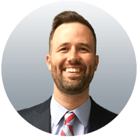 charlie with short brown hair in a suit jacket and striped tie